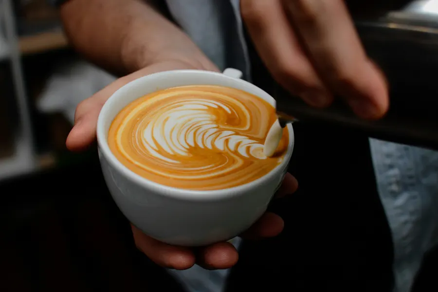 A latte held in two hands