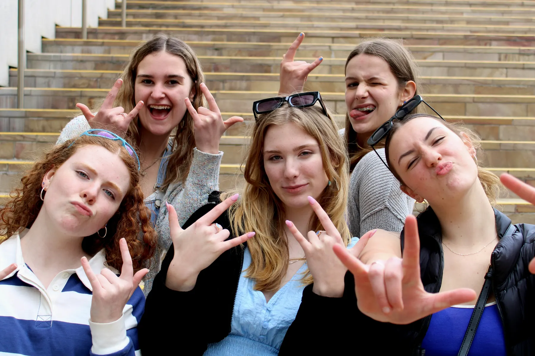 Friends laughing together on the school steps
