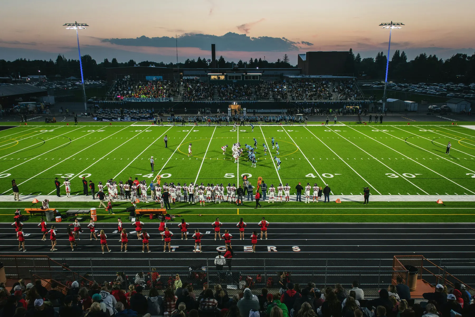 Stadium lights over the football field at dusk